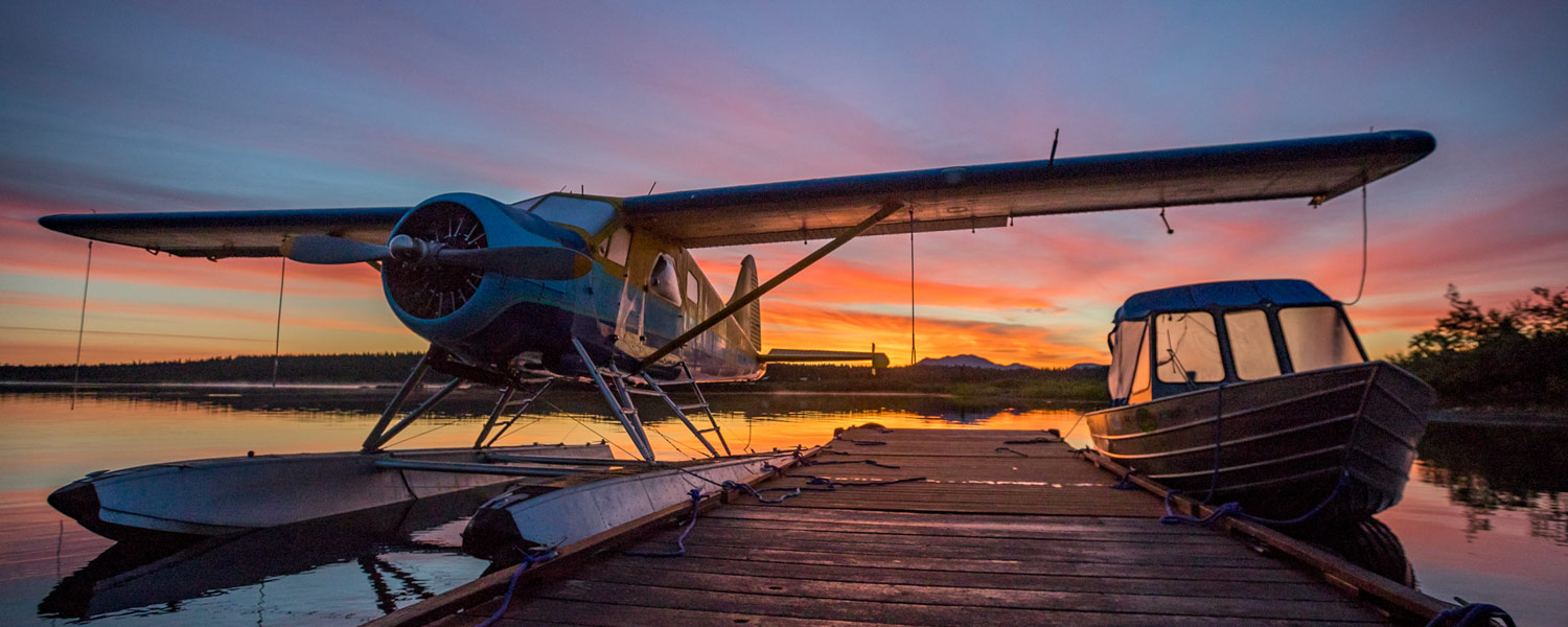 Boat and Plane at dock with Alaskan sunset